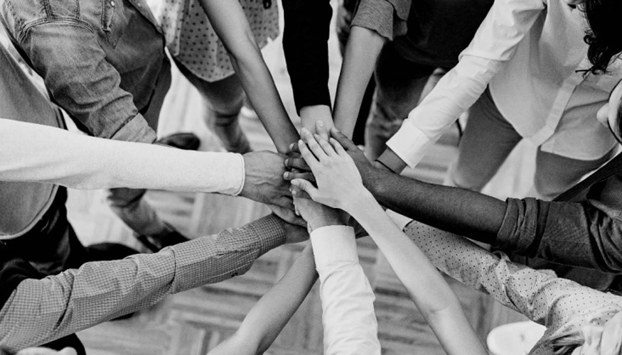 hands of people with different races all together in a huddle