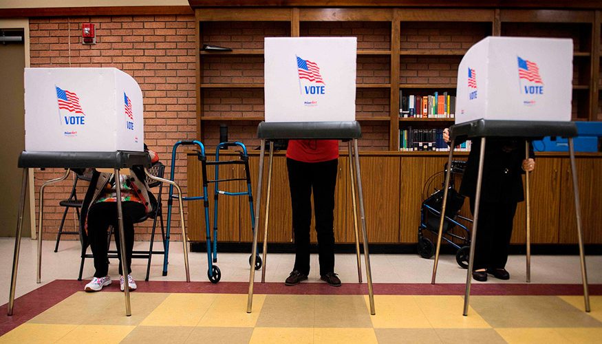 three people voting in the election polls