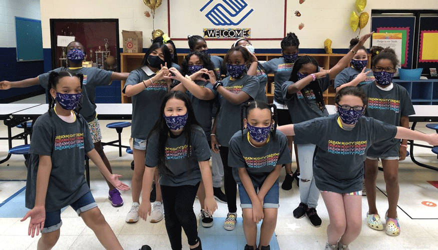 camp attendees pose in matching T-shirts and masks