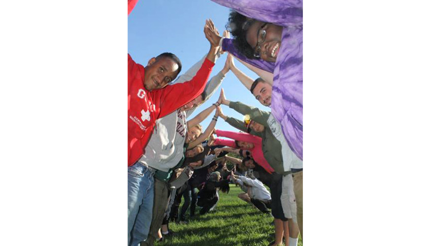 A photo of diverse students making a human tunnel