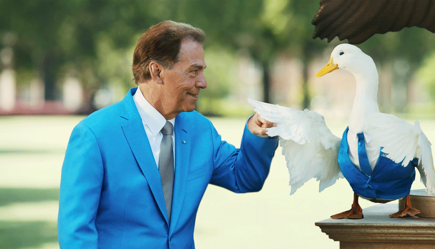 Football Coach Nick Saban fist-bumping the Aflac duck