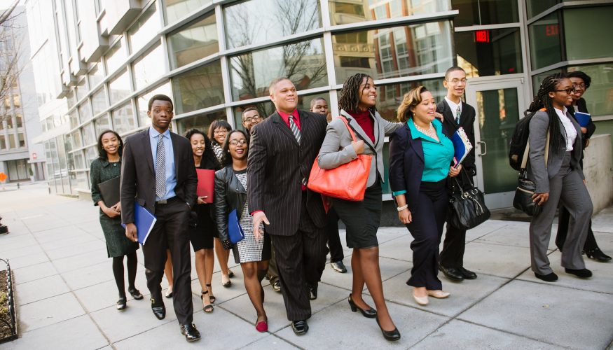 group of working professionals walking outside of building